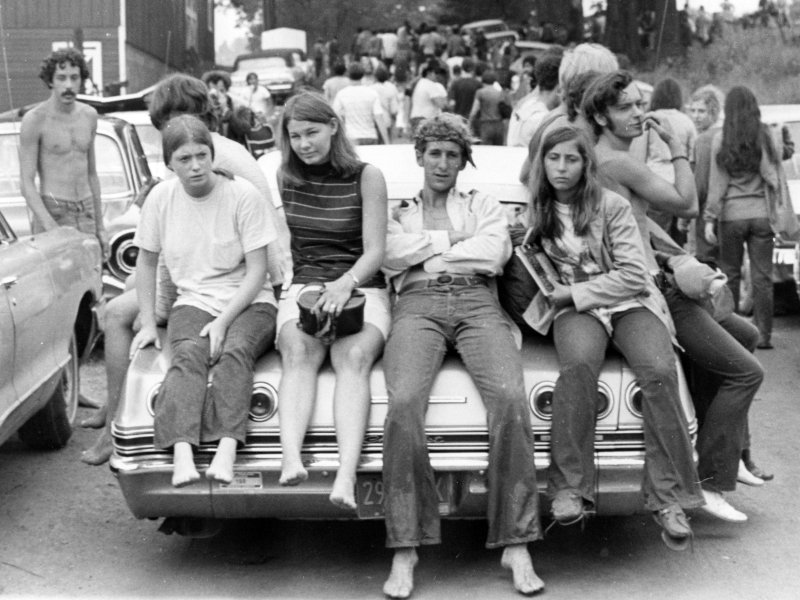 Barn som sitter på en bil under Woodstock-festivalen (foto: Ric Mannining, CC:by-nc-sa)